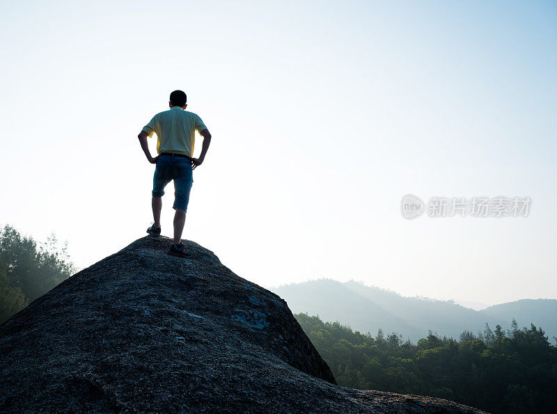 男性徒步旅行者站在岩石上