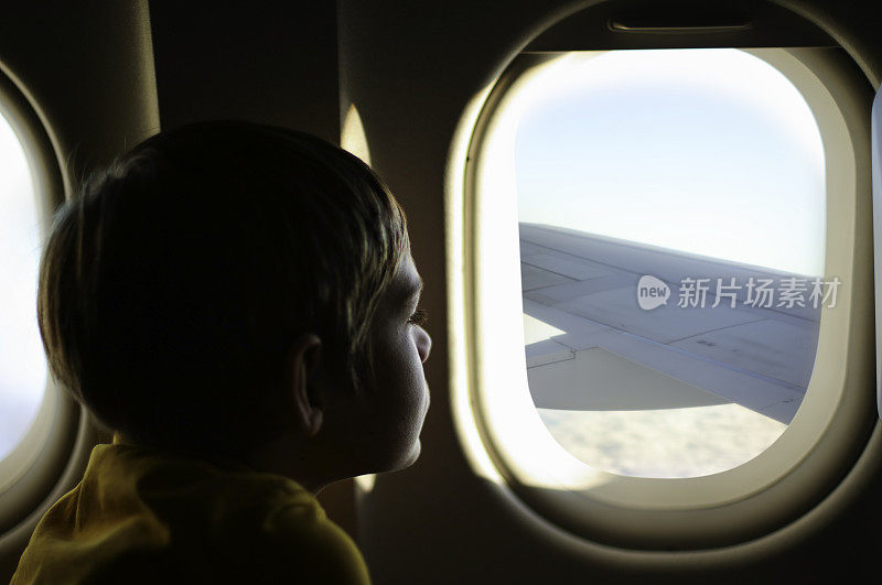 男孩望着飞机窗外