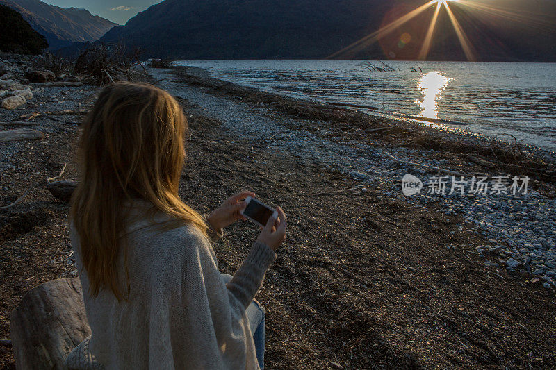 湖边的年轻女子在用手机发短信