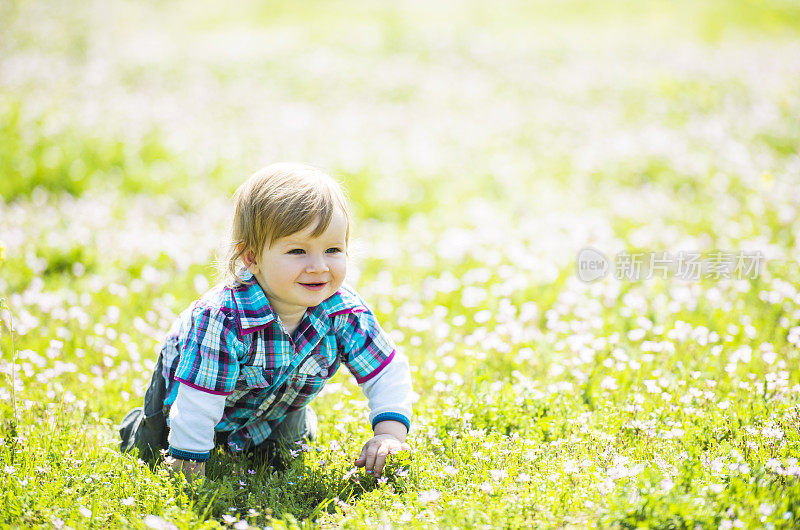 小男孩在草地上爬。