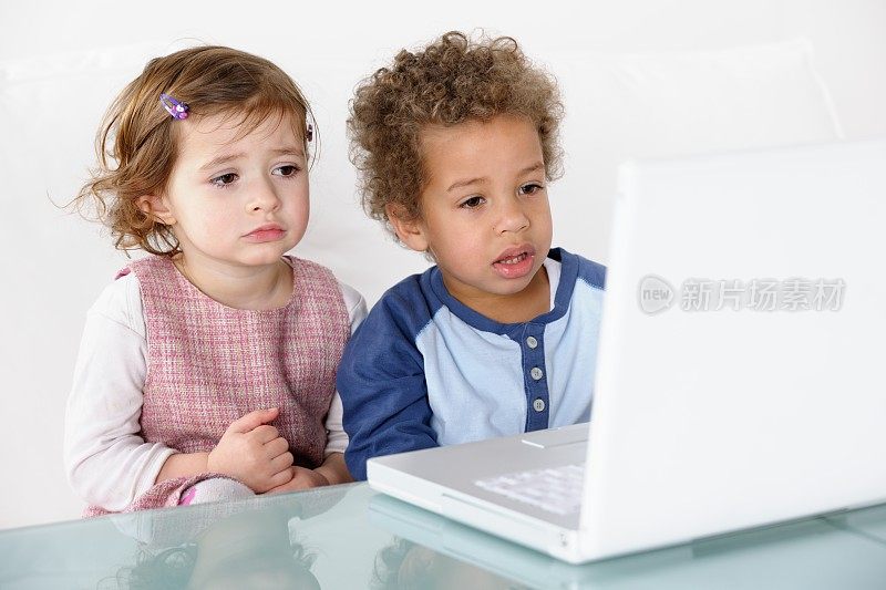 关闭小女孩和男孩使用笔记本电脑