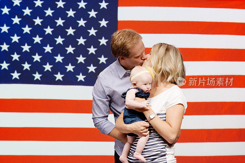 一对情侣在美国国旗前互相亲吻
