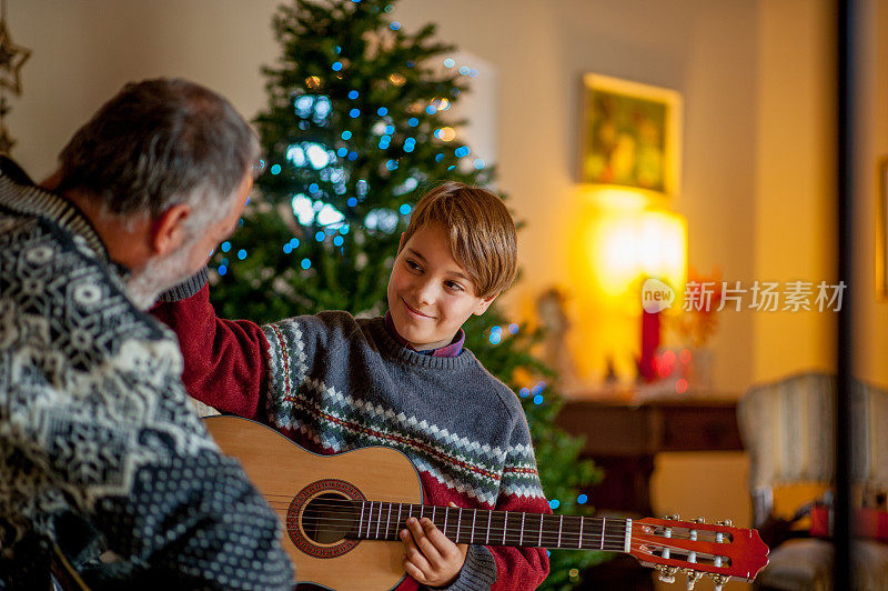 父亲和儿子在圣诞节弹奏吉他