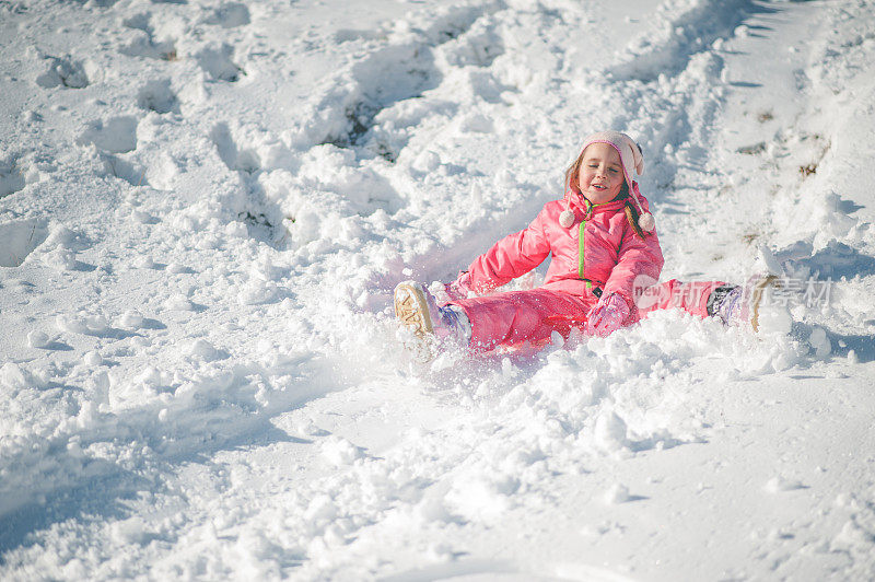 孩子在雪地上滑倒了