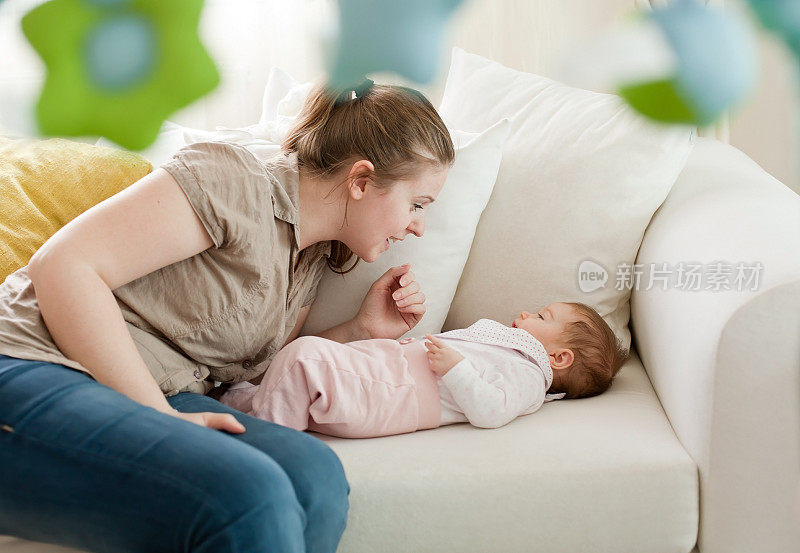 年轻的母亲和她的女儿玩