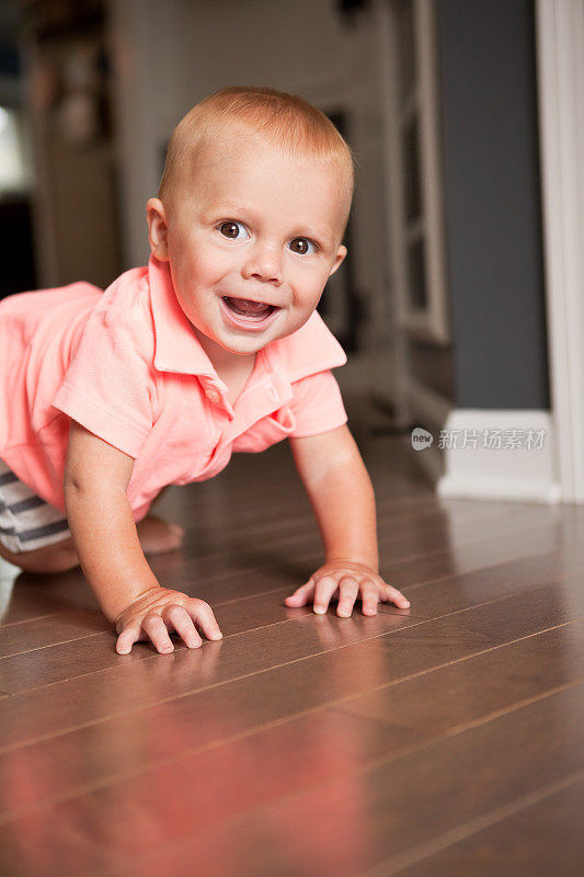 7个月大的小男孩在地板上爬