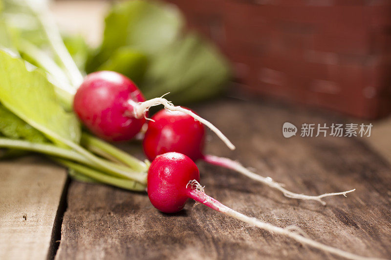 特写镜头。一束刚从花园里摘下来的萝卜。篮子里。