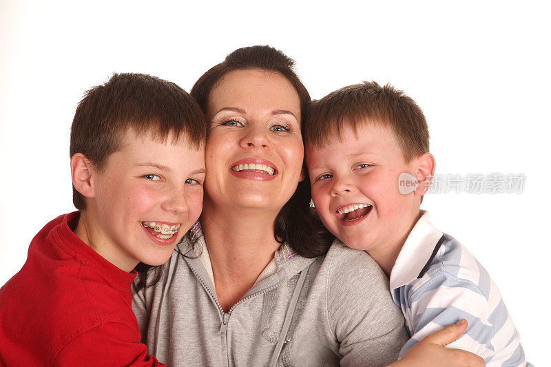 幸福家庭的肖像:两个笑着的儿子和他们的母亲。