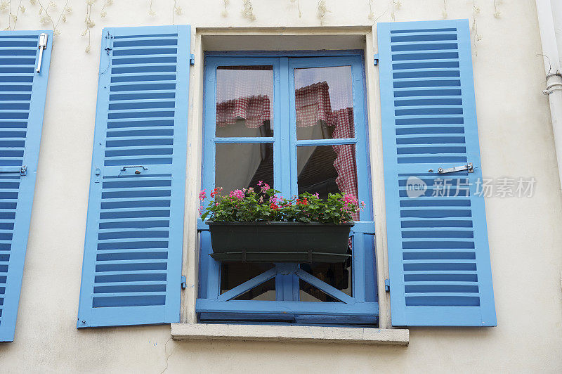亮蓝色传统百叶窗与花盒