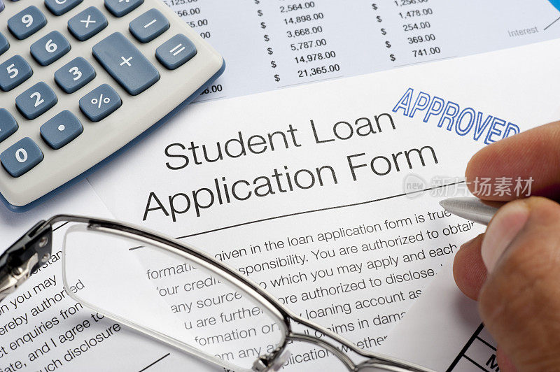 批准的学生贷款申请表连同钢笔、计算器和