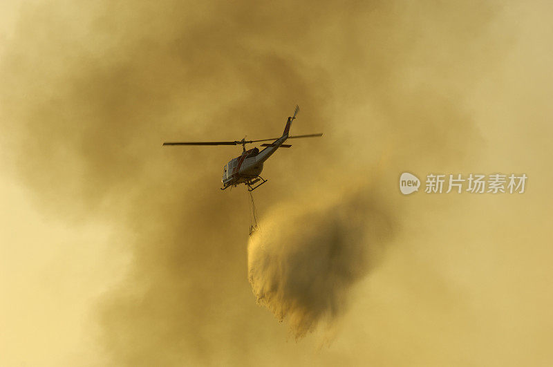 直升机在失控的野火上洒水