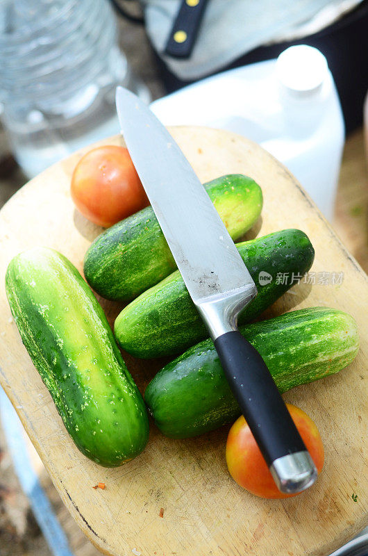 准备用黄瓜、西红柿和刀做沙拉