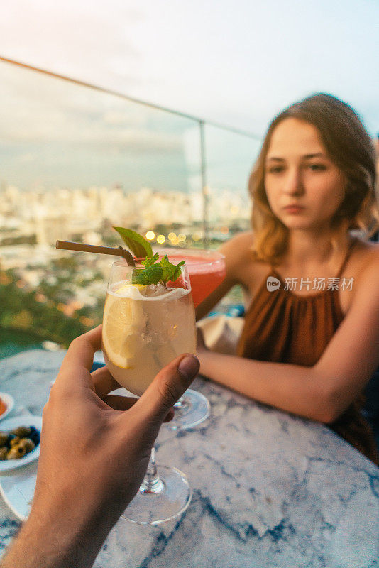 一对夫妇在曼谷的屋顶酒吧喝酒