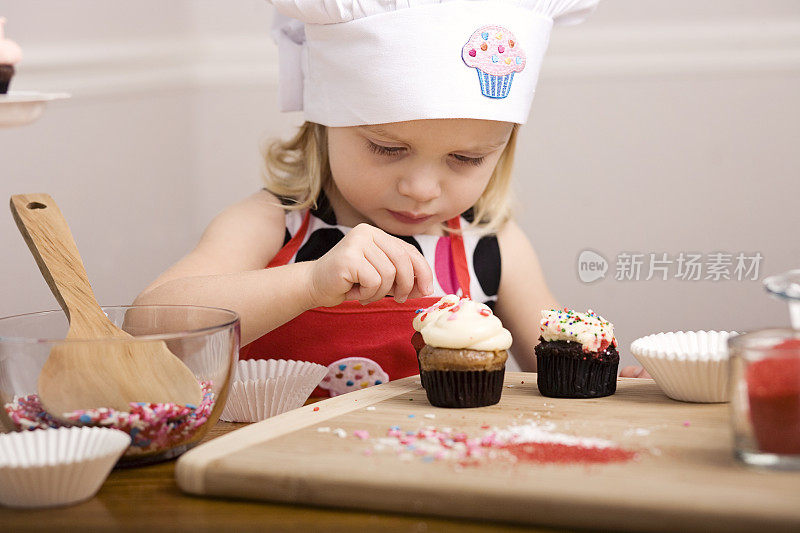 小女孩近距离装饰纸杯蛋糕