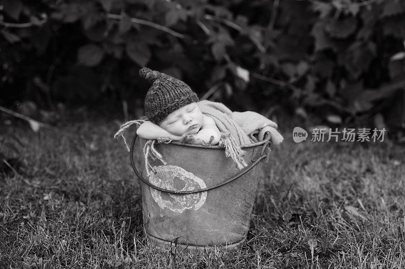 刚出生的男孩睡在外面的桶里