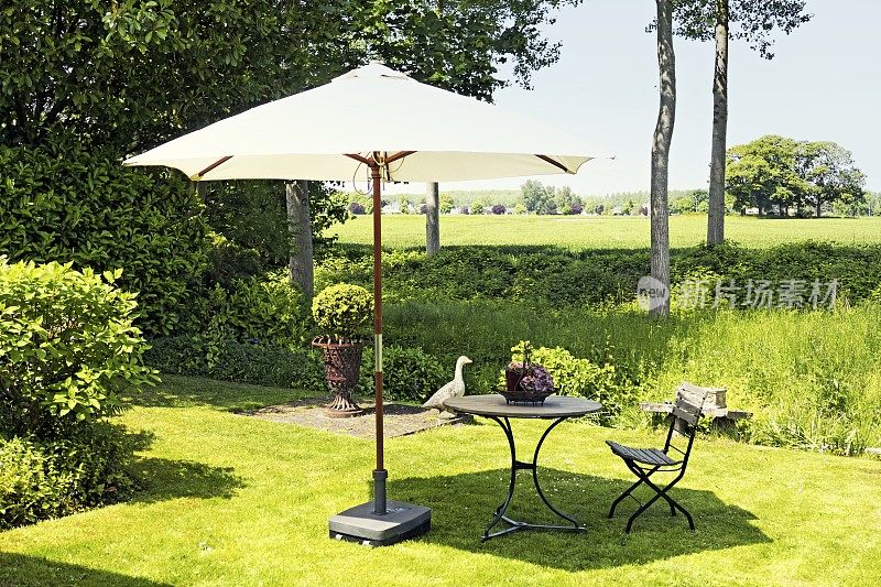 花园阳伞与户外桌椅在草坪上