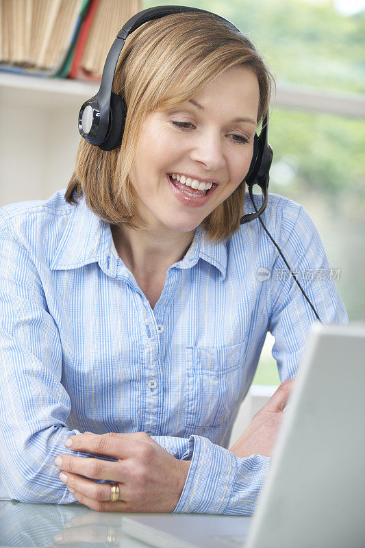 女人戴着耳机在网上聊天