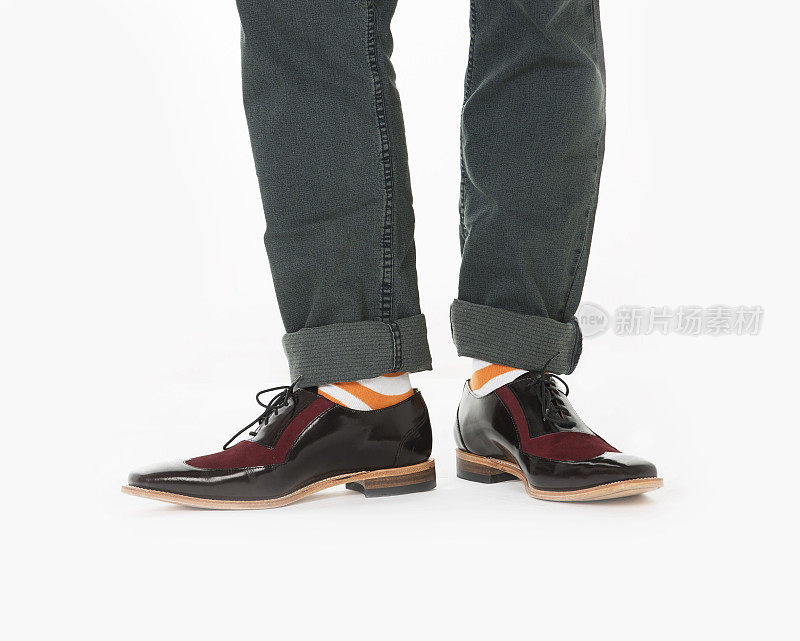 时髦的鞋子配亮橙色的袜子和牛仔裤