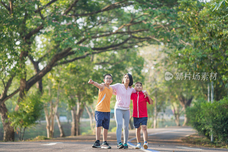 家庭运动快乐活跃的母亲和孩子在户外慢跑，在森林里跑步