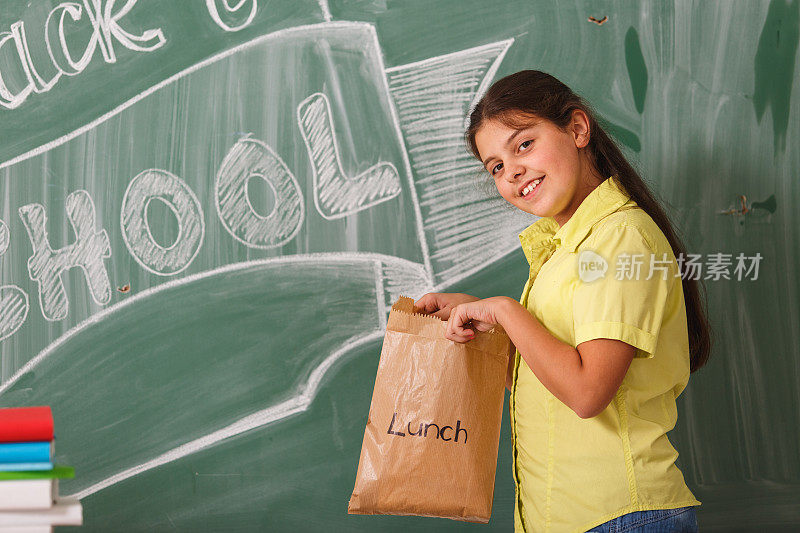 一个拿着午餐袋的小女生
