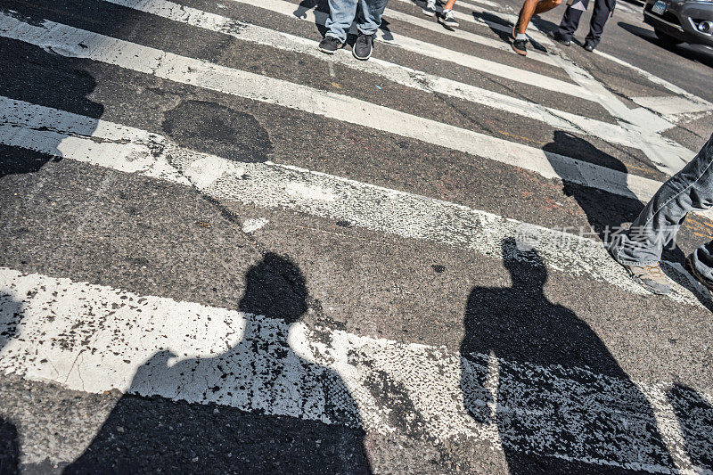 人们在纽约第五大道上走过人行横道。