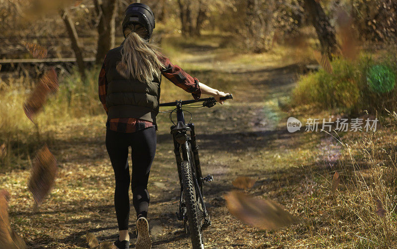 秋天，在森林里骑山地车下坡的女人