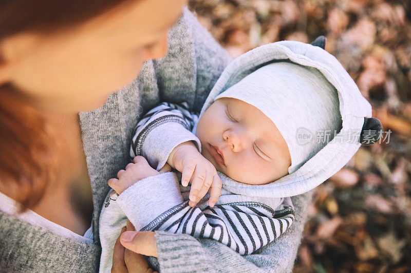 母亲和婴儿的肖像。熟睡的新生婴儿在他妈妈的手中。