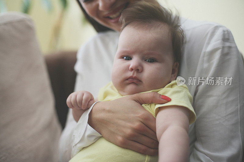 快乐的年轻母亲和她的宝贝女儿在家里。关闭了。