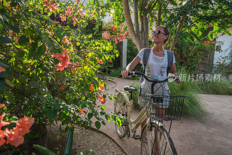 旅游女孩推着自行车在旅游胜地的早上