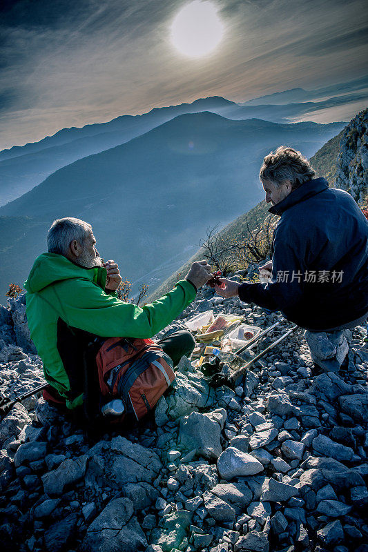 在欧洲南朱利安阿尔卑斯山脉吃早餐的老年男性徒步者