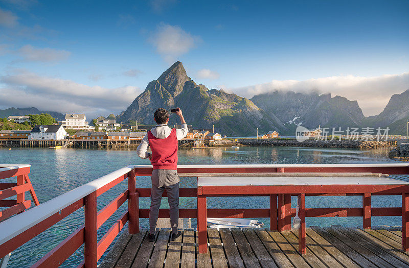 游客欣赏挪威罗浮敦群岛的夏日日落风景
