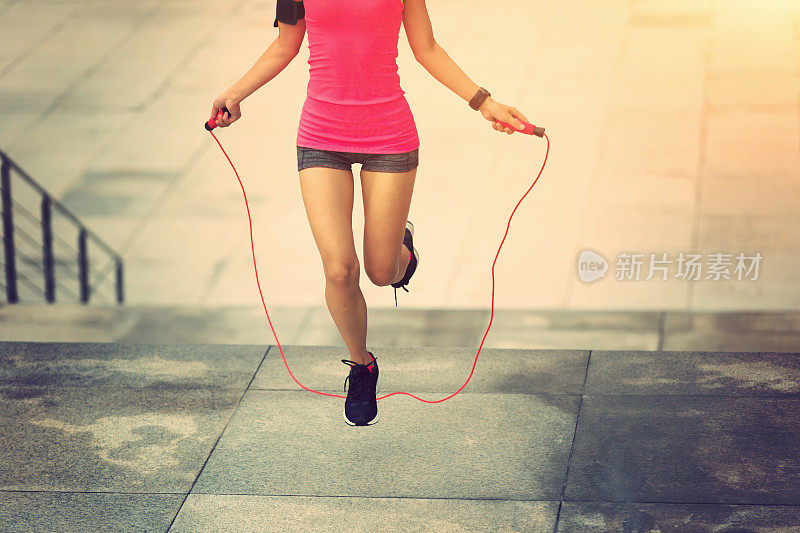 年轻的健身女子在城市跳绳