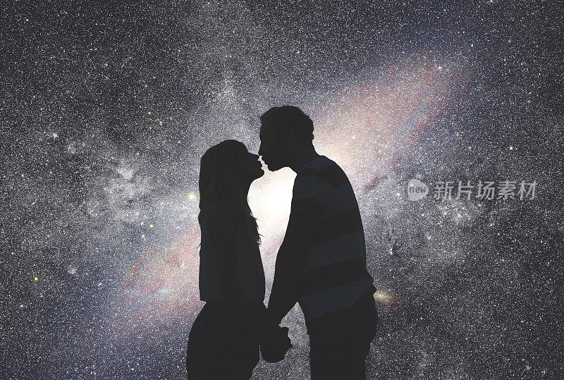 星空下一对年轻夫妇的剪影。我的天文工作。