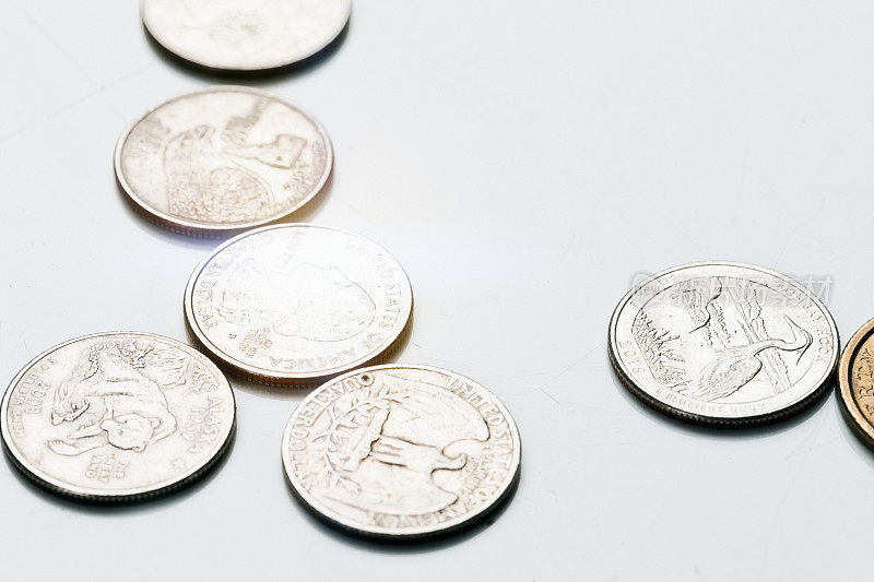 明亮的美国硬币散落在白色的表面上