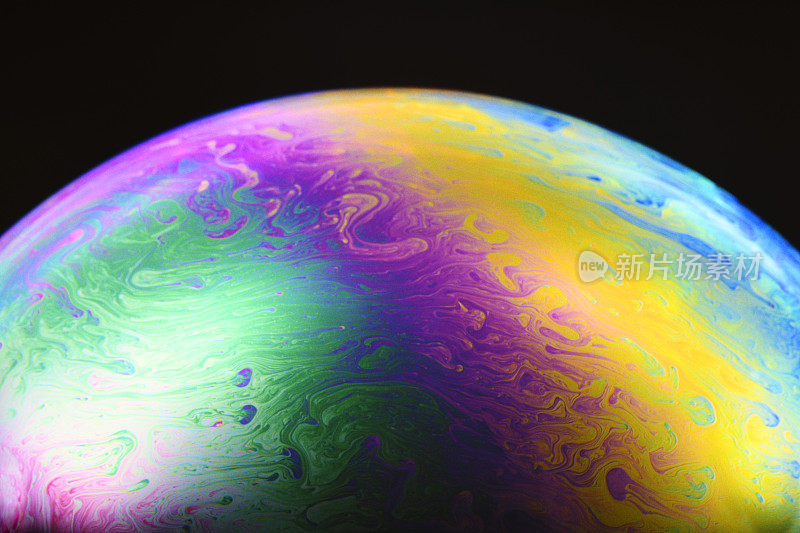 彩虹色的肥皂泡沫的特写在黑色的背景