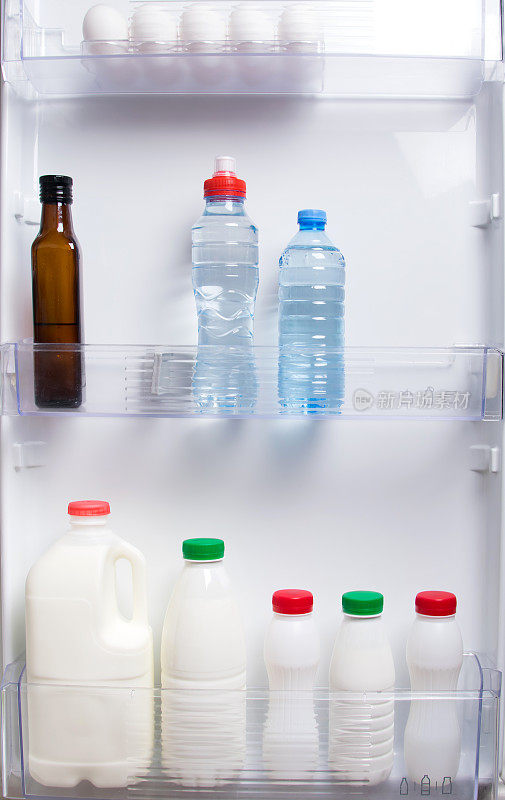 白色冰箱门的架子上放着乳制品、酸奶、奶油和水