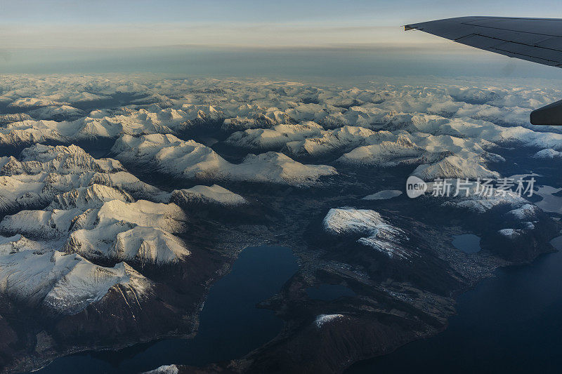 乘客从飞机上俯瞰挪威的峡湾，山上覆盖着积雪