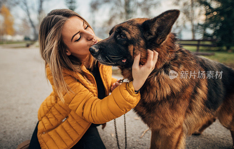 年轻女子和德国牧羊犬在公园里玩