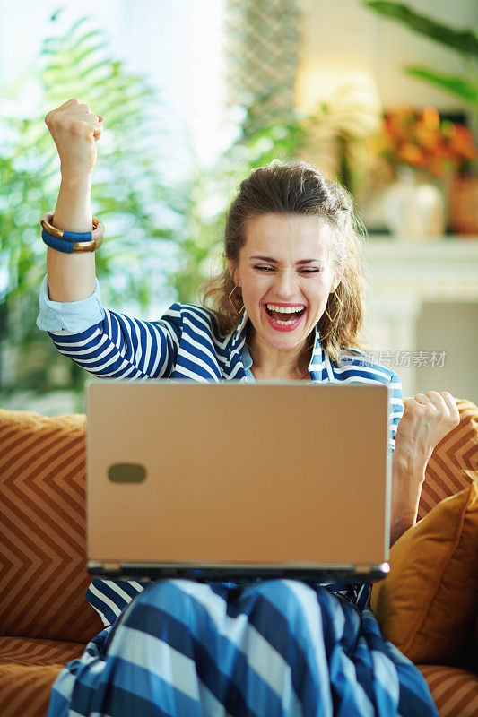 快乐的女性与笔记本电脑和张开双臂欣喜