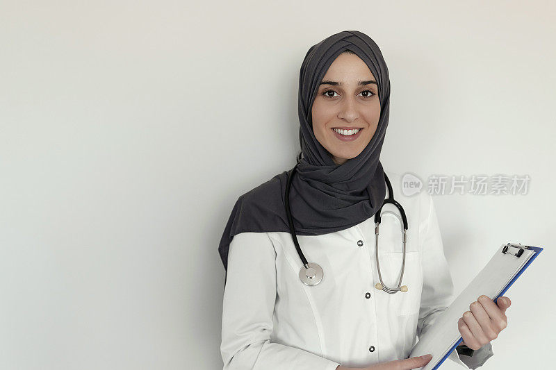 穆斯林护士拿着书写板微笑