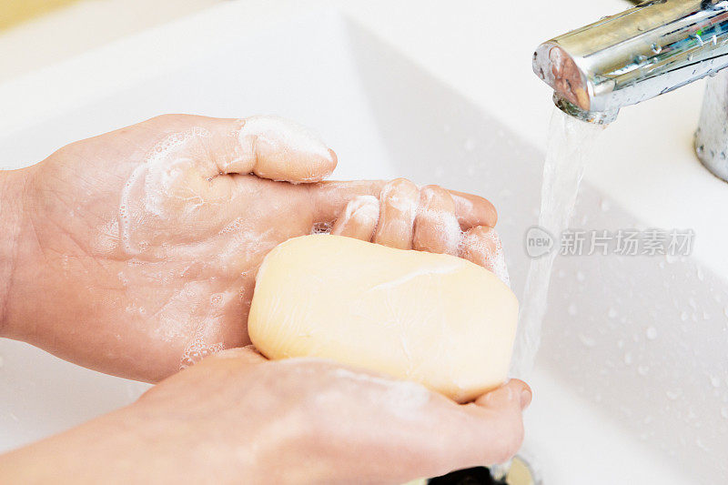 青少年示范在浴室用肥皂彻底洗手