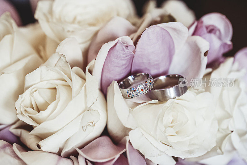 一对结婚戒指放在婚礼花束上