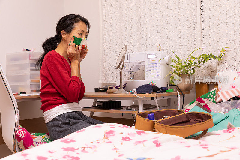 一名日本妇女在家里制作面具