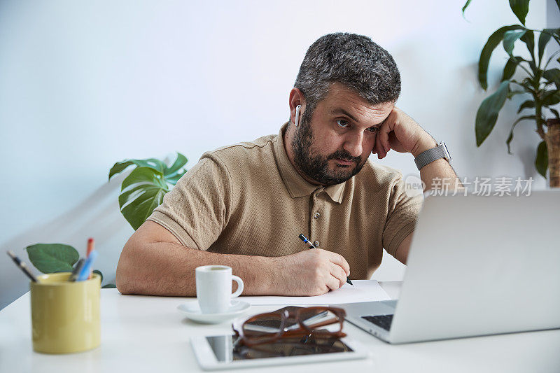 一个年轻人在他的家庭办公室里对着电脑说话