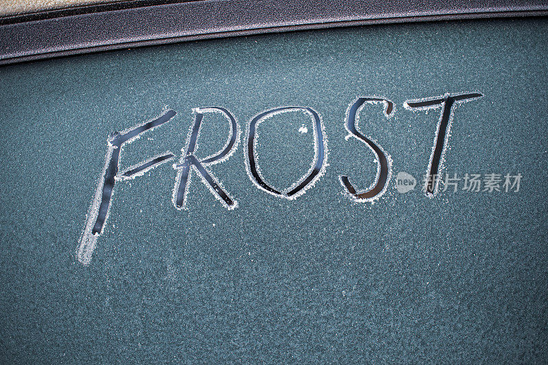 在一辆结霜的汽车挡风玻璃上，手写着“FROST”(霜冻)一词