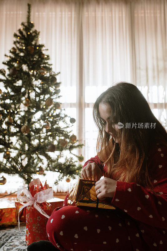 年轻女子打开圣诞礼物