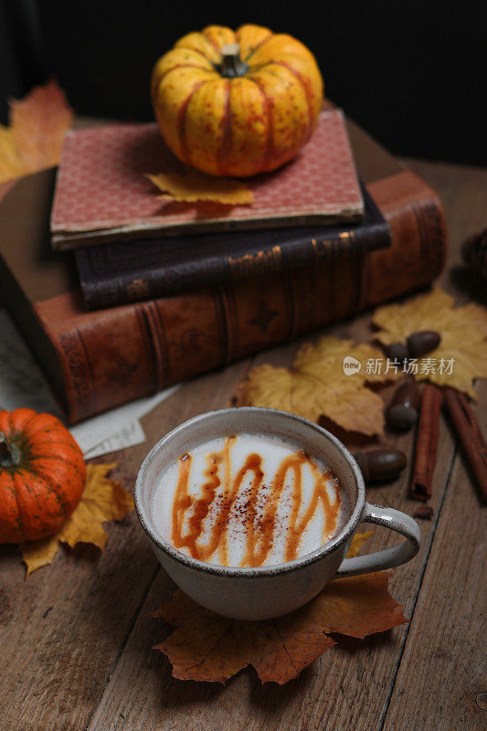 秋天的静物杯和彩色的枯叶在木板上
