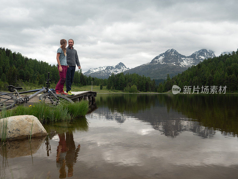 两个山地自行车手在湖边放松