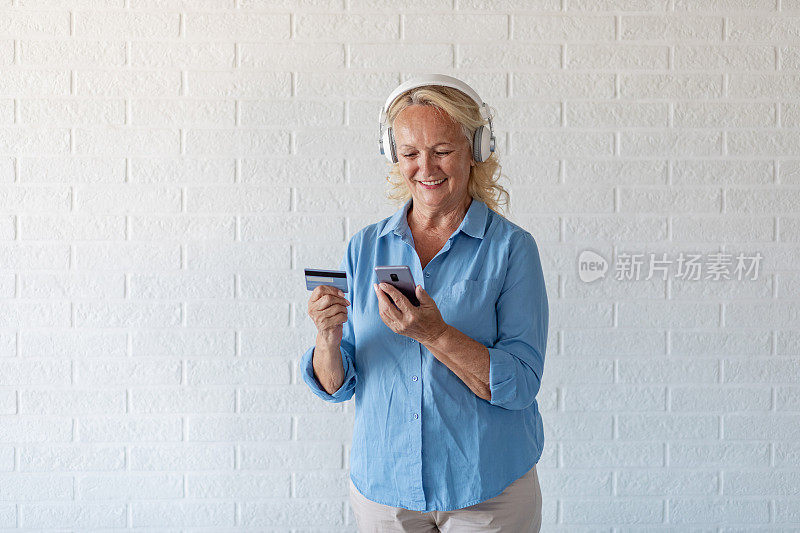快乐的老女人在网上购物的摄影