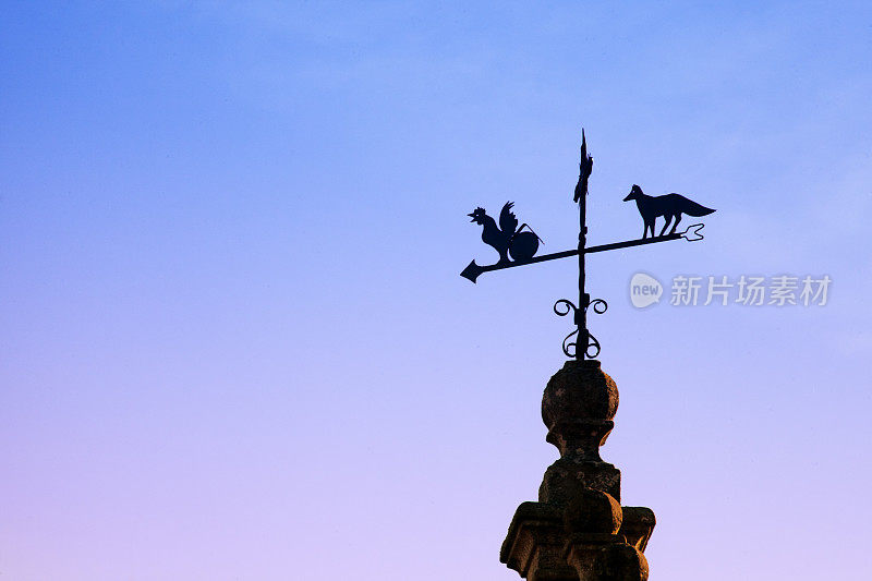 风向标为公鸡和狐狸形状，日落背景。